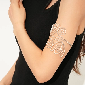 Detailed macro of silver twisted metal spiral arm cuff on model arm in black dress