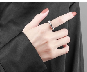 Macro view of silver beaded fidget ring for anxiety relief worn on model finger