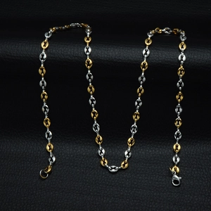 Macro detail of 5mm two-tone stainless steel coffee bean link necklace on black leather