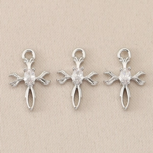 Macro shot of silver baroque cross pendants with central gemstone for DIY jewelry