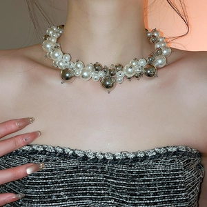 Macro shot of French style irregular clustered pearl and silver bead necklace on collarbone