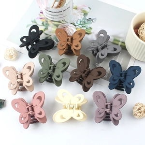 Elegant butterfly hair clips set in ten Morandi colors on marble surface display