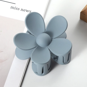 Close-up of matte blue flower hair claw clip with a durable metal spring detail