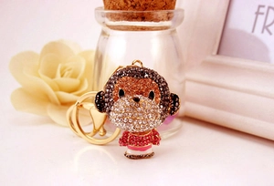 Detailed view of monkey keychain with sparkling gold, brown and red rhinestones