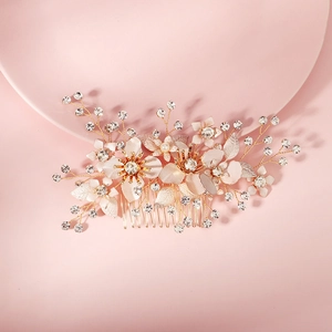 Detailed close-up of bridal hair comb with rose gold flowers, pearls, and rhinestones
