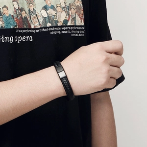 Close-up of men's braided leather bracelet with matte black magnetic steel clasp