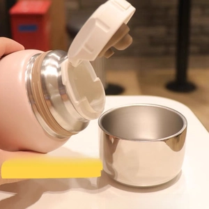 Detail of pink thermos with U-shaped spout and lid used as a cup for smooth pouring