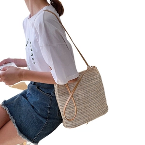 Handmade straw woven shoulder bag for women featuring slim leather straps for summer beach style