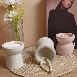 Minimalist geometric hourglass candle holders and resin jewelry dishes on woven mat