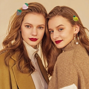 Close-up of fruit hair clips including peach, grape, and lemon styles worn by models