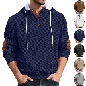 Close-up of textured navy blue hoodie with button neckline and geometric jacquard pattern