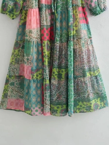 Détail de robe bohème à col en V avec imprimés paisley fleuris et design en patchwork