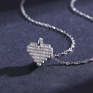 Collier cœur en argent s925 avec cristaux pavés sur un fond sombre élégant
