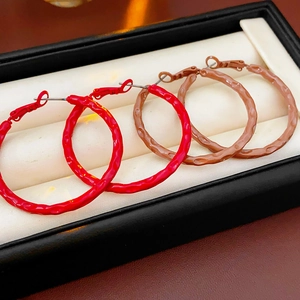 Close-up of vintage textured hoop earrings in red and brown colors in a gift box