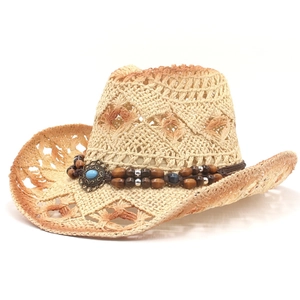 Close-up of woven straw cowboy hat featuring wooden beads and turquoise stone detailing