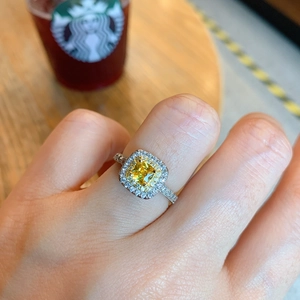 Macro detail of silver ring with square yellow gemstone and sparkling side stones