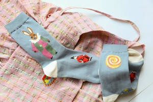 Detail view of blue cotton socks featuring a cute cartoon rabbit jacquard pattern