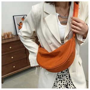 Chic orange nylon crescent crossbody bag styled with a modern cream blazer outfit