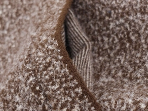 Macro detail of brown and white textured wool knit fabric on a vintage cocoon sweater
