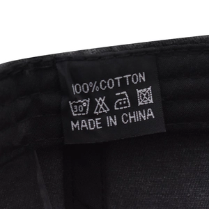 Detail of 100% cotton material tag and care instructions for the baseball cap