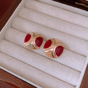 Macro view of vintage red enamel square earrings with gold plating and sparkling crystals