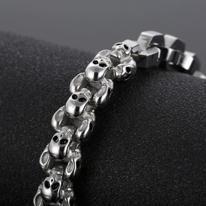 Macro shot of polished silver skull link chain bracelet in punk stainless steel style