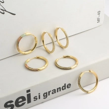 Detail of six gold-plated hoop earrings with micro-pave cubic zirconia on a white prop