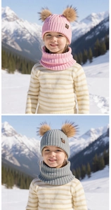 Detail of children's knit winter hat with double fur pom-poms and matching neck warmer