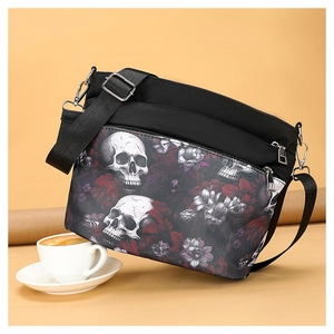 Detail view of black nylon crossbody bag featuring white skull and purple floral prints