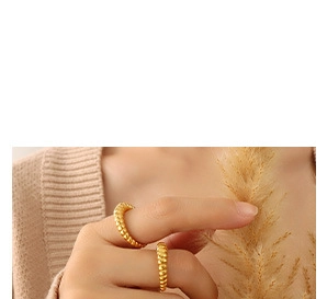 Detail shot of stackable 18K gold plated croissant dome rings on a model finger