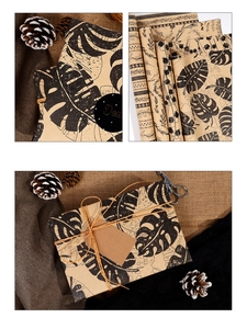 Detail of vintage kraft wrapping paper featuring black tropical leaf and floral patterns