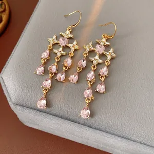 Vintage style gold earrings with pink heart gemstones and dangling tassel star details