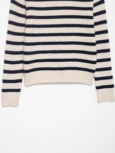 Detailed close-up of ribbed cuffs and striped texture on a knitted crewneck sweater