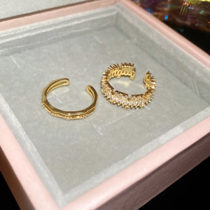 Detail of 18k gold plated open rings set with square cubic zirconia in a jewelry box