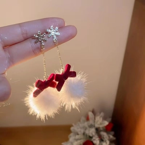 Detail of snowflake earrings with red velvet bow and white pom pom pendant