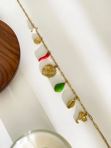 Detailed close-up of 18K gold-plated necklace with diverse enamel heart and shell charms