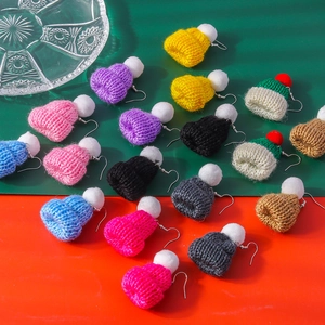 Macro detail of a colorful knitted mini hat earring with realistic woolen texture