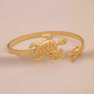 Goldener Armreif mit Meeresschildkröten-Motiv und drei detaillierten Schildkröten-Elementen
