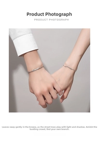 Close-up of couples sterling silver bracelets with flat chain and branch design