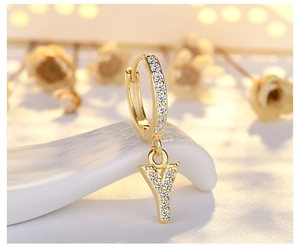 Macro shot of gold letter Y earring hoop with pavé zircon stones on ceramic base