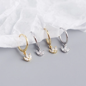 Detailed view of silver and gold geometric hoop earrings with marquise zircon charms
