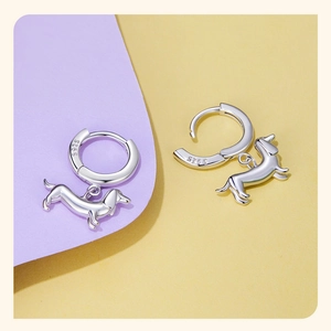 Macro detail of S925 sterling silver dachshund dog dangle charm on hoop earrings
