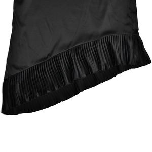 Close-up of the ruffled fishtail hemline on a sleek black satin bodycon skirt