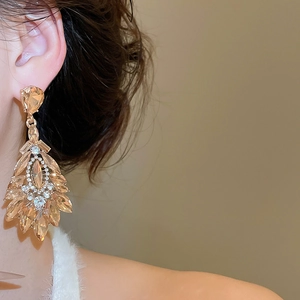 Gros plan de boucles d'oreilles pendantes en cristal champagne au style vintage