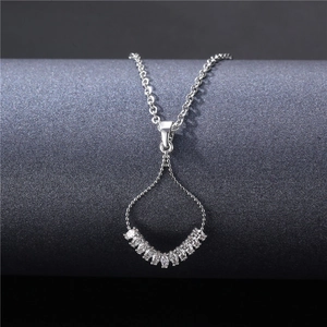 Elegant silver fan necklace with zircon pavé pendant on a dark minimalist display