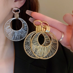 Detail of woven mesh texture on hollow hoop earrings with gold and silver finish