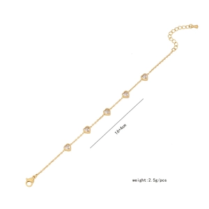 Detail of gold heart bracelet with five clear heart-shaped zircons and lobster clasp