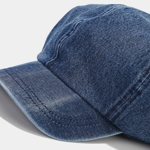 Close-up of blue denim octagonal hat showing twill texture and distressed white wash detail