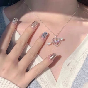 Pink heart Cupid arrow pendant necklace in silver, elegantly worn on neck with close-up view