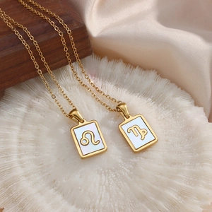 Zodiac gold necklaces with rectangular shell pendants on silk, featuring Leo and Capricorn